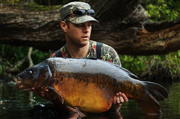 Two Senior Fishermen with a Big Carp on a Fishing Rod Stock Photo