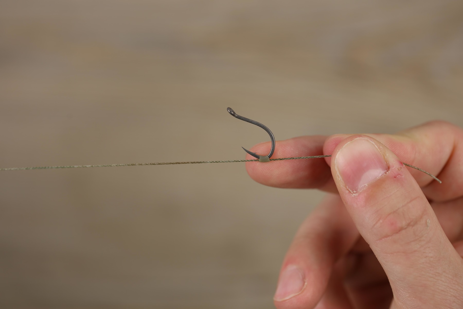 Pass your hook point through it (being careful not to pierce the side!).